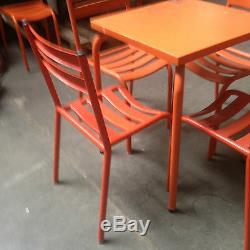 Table de bistrot avec quatre chaises en metal patine orange. XX siècle