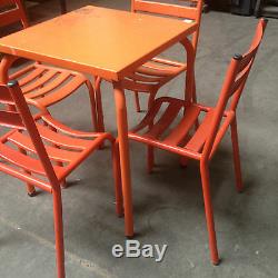 Table de bistrot avec quatre chaises en metal patine orange. XX siècle